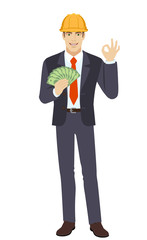 Businessman in construction helmet with money showing a okay hand sign