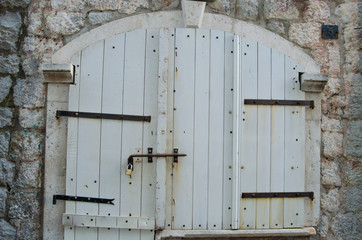 Old wooden, white the door closed on iron bolt.