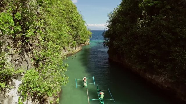 Aerial view two traditional fishing boats sailing on Bojo River towards the sea, Aloguinsan, Philippines.