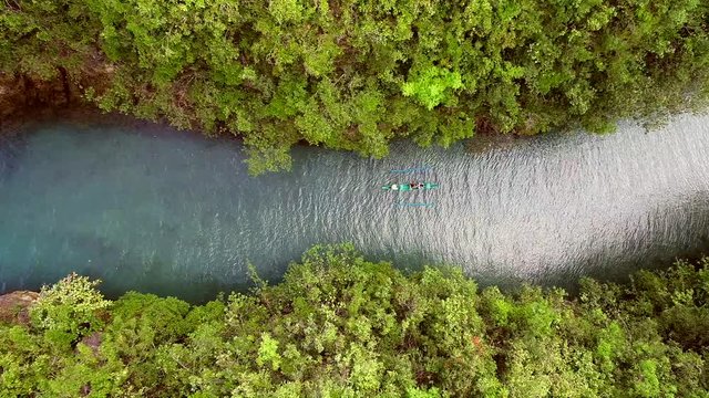 Aerial view of traditional fishing boat sailing in Bojo River, Aloguinsan, Philippines.