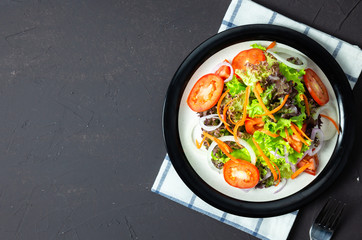 vegetable salad tomato, carrot, onion, spinach, and lettuce on black board