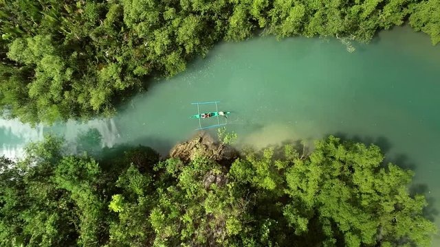 Aerial view above traditional fishing boat sailing in Bojo River, Aloguinsan, Philippines.