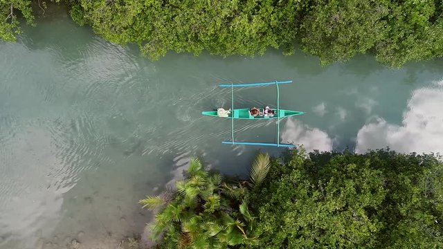 Aerial view of traditional fishing boat sailing in Bojo River, Aloguinsan, Philippines.