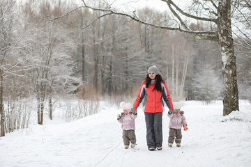 Fototapeta na wymiar Children walk in the park in winter. Winter forest a family with children on a walk. A cold winter day is a family walk.