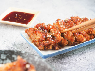 Deep-fried Chicken and sesame. Uses chopsticks to pickup tasty fried chicken, selective focus.
