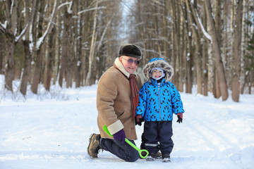 Fototapeta na wymiar Kid with family have fun in a winter park