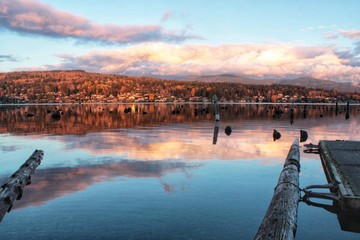 Beautiful reflection  over pacific northwest lake at sunset with cloudy sky
