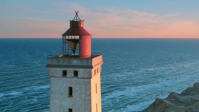 Cinematic aerial shot rotating around a disused lighthouse