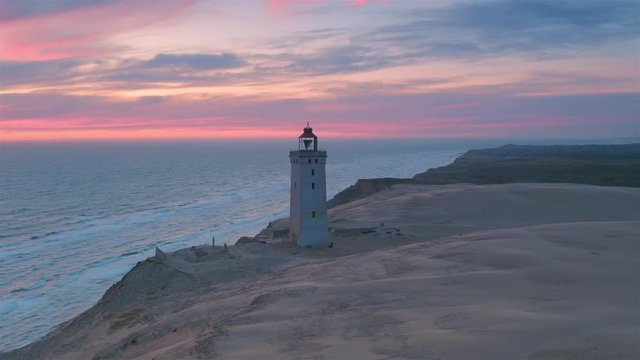 Stunning aerial wide shot of Rubjerg Knude lighthouse at sunset