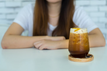 Nitro Cold Brew Coffee with Peach fruit on white table with blur female background
