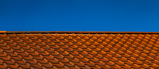 Rotes Ziegeldach mit blauem Himmel