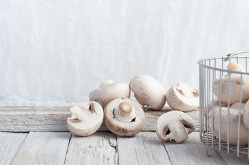 Champignon mushrooms on a white wooden table