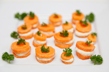 Raw Organic Food. Small Carrot Sandwich Bites With Creamy Vegan Stuffing And Parsley On Top. Close-up, served food, isolated on white background.