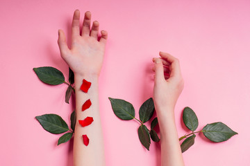 Nude manicure.Natural beauty girl hands ,hand cosmetics with flower extract, product.Fashion woman hand with flower and leaves,herbal skin care pink background studio shot