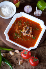 Delicious rich borscht with beef is on the table in the restaurant.