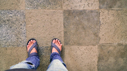 Man wearing blue slippers on the floor walkway paved with slabs., Background design