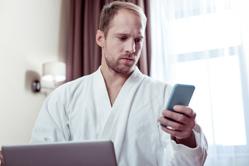 Close up of businessman holding blue phone reading messages