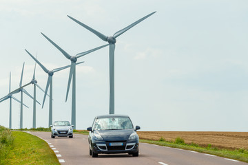 Wind turbines of a power plant for electricity generation close to country road in Normandy,...