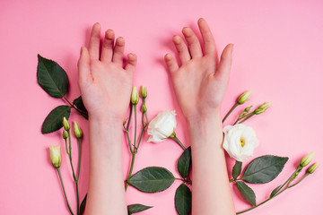 Nude manicure.Natural freshness and youth girl hands ,hand cosmetics with white rose flower extract, product.Fashion woman hand with flower and leaves,herbal skin care pink background studio shot