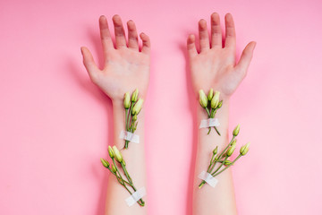 Nude manicure.Natural freshness and youth girl hands ,hand cosmetics with white rose flower adhesive plaster .Fashion woman hand with flowers and leaves,herbal skin care pink background studio shot