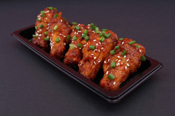 Korean fried chicken with black backdrop.