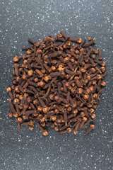 Whole clove heads and pieces isolated over black