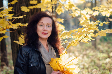 beautiful woman 50 years in autumn forest