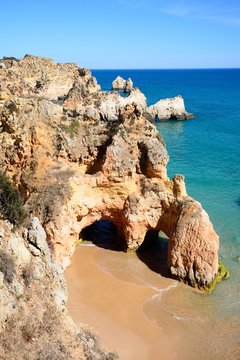 Elevated view of the cliffs with a small secluded beach in the foreground, Praia da Rocha, Portimao, Portugal.