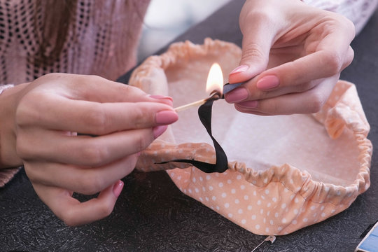 Woman scorches the edge of the tape lit a match. Close-up hands.