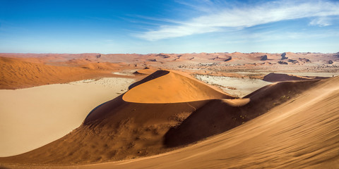 Panoramic view of Deadvlei and Sossusvlei dunes under blue sky from Big Daddy dune. Namib Naukluft...