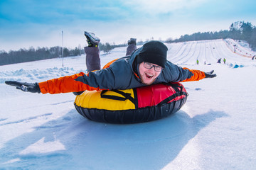 man snow tubing from hill. winter activity