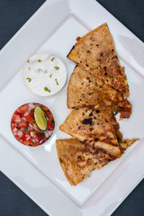 Spanish or Mexican dish Quesadilla served with salad and sauce