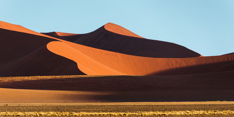 Panoramic view of a Sossusvlei big orange sand dune against blue sky, Namibia