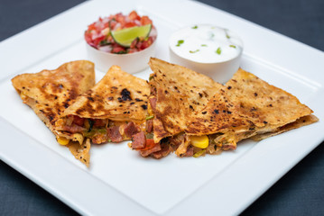 Spanish or Mexican dish Quesadilla served with salad and sauce