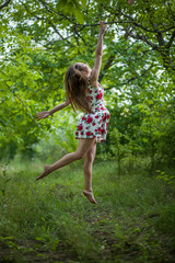 pretty young woman jumping on green park