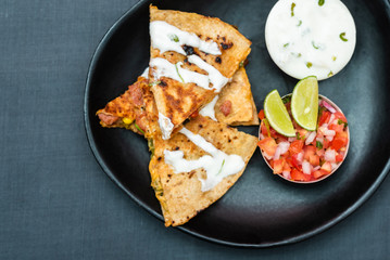 Spanish or Mexican dish Quesadilla served with salad and sauce