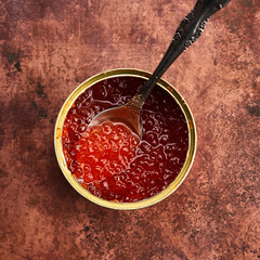 red caviar in a tin with spoon