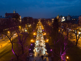 overhead view of european city in night time. people walk by fair in evening