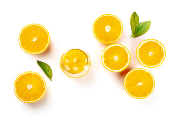 An overhead photo of a glass of fresh orange juice with orange halves and green leaves, shot from the top on a white background with copy space