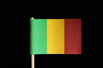 A official and original flag of Mali on toothpick on black background. Consists of a vertical tricolour of green, gold and red.