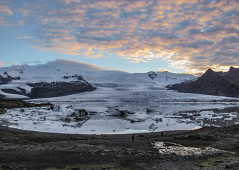 Iceberg lagoon Fjallsarlon with floating icebergs and dramatic sky reflection in water, Southern Iceland, Europe