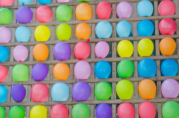 Wooden stand with rope colorful and balloons. Colorful multicolored balloon abstract background. Amusement throwing darts at balloons.