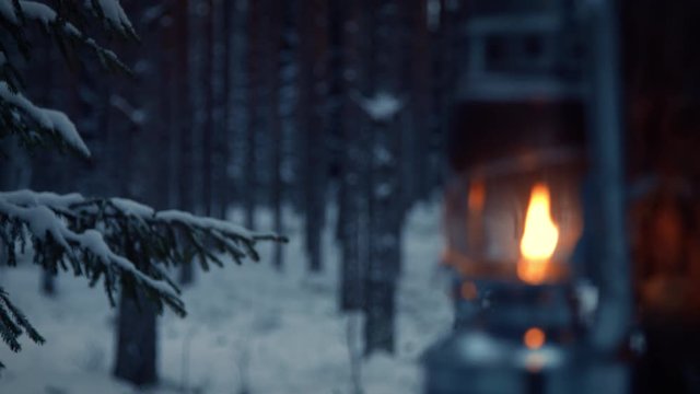 Lantern hanging on a tree in snow covered forest in winter