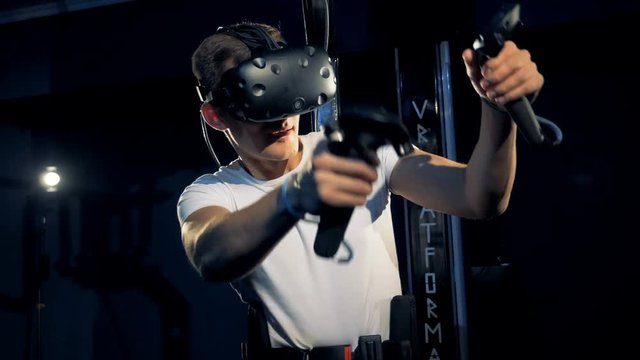 Virtual reality platform is being used by a young man in gaming process. Virtual reality gaming concept.
