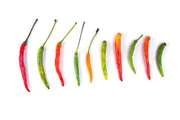 Group of red green and yellow peppers on white background