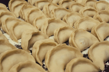 Obraz premium Dumplings pelmeni before cooking. Russian cuisine background