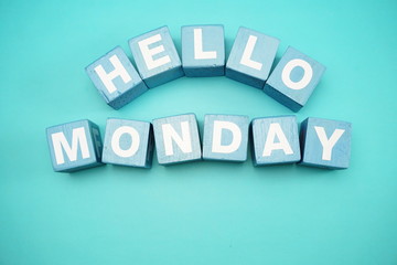 hello monday with blue wooden cubes alphabet letter on blue background