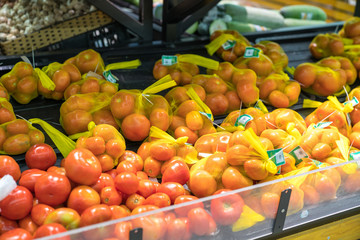 Fresh healthy fruits on shelves in supermarket. Ripe tomato