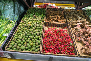 Vegetables on shelves in supermarket with fresh chilli, dry onion, dry ginger, dry citronella...