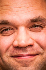 Cunning, positive, squinting man. Facial expression, emoji face, emotion close-up.